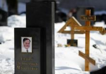 A picture of lawyer Sergei Magnitsky is seen on his grave in the Preobrazhensky cemetery in Moscow, March 11, 2013. PHOTO BY REUTERS/Mikhail Voskresensky