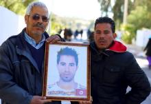 Othman Yahyaoui (L) holds a photograph of his son Ridha Yahyaoui, who committed suicide, in Kasserine, Tunisia, January 21, 2016. PHOTO BY REUTERS/Amine Ben Aziza
