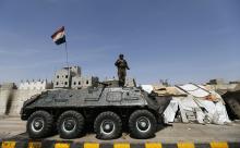 A police trooper stands on an armoured personnel carrier (APC) at a checkpoint in Sanaa