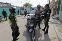 A member of the Military Police for Public Order (PMOP) asks a man for his identification as others keep watch during a patrol at the impoverished Flor del Campo neighbourhood in Tegucigalpa, Honduras, April 29, 2015. PHOTO BY REUTERS/Jorge Cabrera