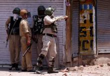 An Indian policeman uses a slingshot to hurl stones towards protesters during a clash on the occassion of the death anniversary of Burhan Wani, a commander of the Hizbul Mujahideen militant group, in downtown Srinagar, July 8, 2017. PHOTO BY REUTERS/Danish Ismail