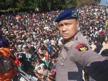 Chief Water Police of Lombok Dewa Wijaya takes a picture in front of hundreds of people attempting to leave the Gili Islands after an earthquake Gili Trawangan, in Lombok, Indonesia, August 6, 2018, in this picture obtained from social media. PHOTO BY REUTERS/Indonesia Water Police