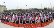 Police wearing sashes hold placards during a ceremony to award those who the authorities say participated in "the crackdown of violence and terrorists activities" in Hotan, Xinjiang Uighur Autonomous Region, August 3, 2014. PHOTO BY REUTERS/Stringer