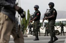 Police officers patrol near a journalist during a protest by the Abuja. PHOTO BY REUTERS/Afolabi Sotunde
