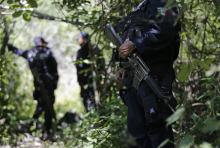 Iguala police officers stand guard at an area near clandestine graves at Pueblo Viejo, in the outskirts of Iguala, southern Mexican state of Guerrero