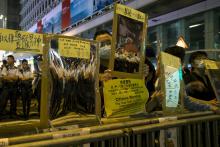 Police officers are reflected on reflective materials held by a pro-democracy protesters on a blocked road at Mongkok shopping district in Hong Kong October 19, 2014. PHOTO BY REUTERS/Tyrone Siu