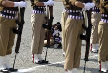 A member of a female Indian police contingent holds her face in her hands as she sits during a parade to mark Police Commemoration Day in Zewan, on the outskirts of Srinagar, October 21, 2014. PHOTO BY REUTERS/Danish Ismail