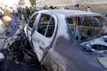 A police investigator looks at a damaged car at the scene of a car bomb outside the police college in Sanaa, January 7, 2015. PHOTO BY REUTERS/Khaled Abdullah
