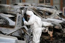 A French police officer inspects burned vehicles outside the Splendid Hotel in Ouagadougou, Burkina Faso, January 17, 2016. PHOTO BY REUTERS/Joe Penney