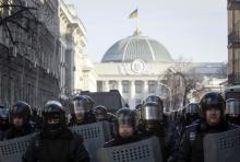 Police troops stand guard during an anti-government rally near the parliament building in Kiev