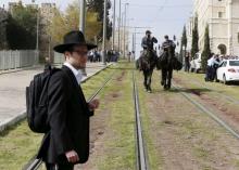 An ultra-Orthodox Jewish onlooker stands near Israeli mounted police near the scene where Israeli police said two Palestinian assailants carried out a drive-by shooting on a commuter bus before being shot dead by police opposite the Notre Dame Center just outside Jerusalem's Old City March 9, 2016. PHOTO BY REUTERS/Ammar Awad