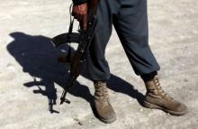 An Afghan policeman with a weapon stands at the site of a suicide attack in Kabul, in this file picture taken July 2, 2013. PHOTO BY REUTERS/Mohammad Ismail