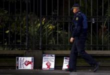 A policeman walks past placards discarded on a footpath outside the Victorian parliament building after protests in Melbourne, Australia, July 18, 2015. PHOTO BY REUTERS/David Gray