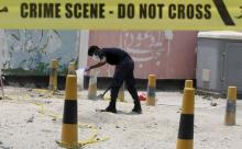 An explosives specialist police officer collects samples after a bomb blast in the village of Sitra, south of Manama, Bahrain, July 28, 2015. PHOTO BY REUTERS/Hamad I Mohammed