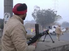 A policeman stands guard with a gun as vehicles pass by, following an attack on an Indian Air Force base in Pathankot on Saturday, near the border with Pakistan, in Ludhiana, Punjab state, India, in this still frame taken from video, January 2, 2016. PHOTO BY REUTERS/ANI/via Reuters
