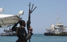 A maritime policeman on a tag-boat guards oil tanker Aris-13, which was released by pirates, as it sails to dock on the shores of the Gulf of Aden in the city of Bosasso, northern Somalia's semi-autonomous region of Puntland, March 19, 2017. PHOTO BY REUTERS/Abdiqani Hassan