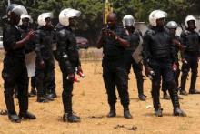 Police officers hold tear gas canisters during an opposition rally in Conakry April 20, 2015. REUTERS/Saliou Samb