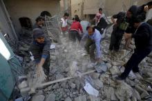 Policemen and medics remove debris as they search for victims at the site of a Saudi-led air strike on the police headquarters in Yemen's capital Sanaa, January 18, 2016. PHOTO BY REUTERS/Khaled Abdullah