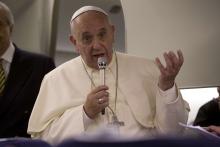 Pope Francis talks to reporters aboard the papal flight on his way back to the Vatican from Jerusalem