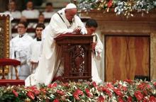 Pope Francis kneels as he leads the Christmas night Mass in Saint Peter's Basilica at the Vatican December 24, 2015. PHOTO BY REUTERS/Tony Gentile