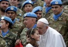 Pope Francis kisses a child as he poses with Argentinian United Nations soldiers during the weekly audience in Saint Peter's Square at the Vatican, February 3, 2016. PHOTO BY REUTERS/Max Rossi