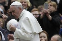 Pope Francis holds a skullcap given to him by a faithful as he arrives to lead the weekly audience in Saint Peter's Square at the Vatican, February 3, 2016. PHOTO BY REUTERS/Max Rossi