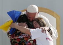 Pope Francis hugs two girls during a meeting with youths at the Jose Maria Morelos y Pavon stadium in Morelia, Mexico, February 16, 2016. PHOTO BY REUTERS/Carlos Garcia Rawlins
