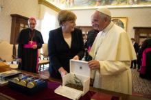 German Chancellor Angela Merkel and Pope Francis exchange gifts during a meeting at the Vatican, June 17, 2017. PHOTO BY REUTERS/Guido Bergmann/Courtesy of Bundesregierung