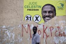 A man walks next to a ripped electoral poster of presidential candidate Jude Celestin in Port-au-Prince, Haiti, January 15, 2016. PHOTO BY REUTERS/Andres Martinez Casares