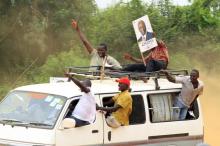 A supporter of Amama Mbabazi, former Ugandan prime minister and presidential candidate for The Democratic Alliance (TDA), holds a poster of him atop a mini bus during a campaign rally ahead of the February 18 presidential election, in Lyantonde town, Uganda January 25, 2016. PHOTO BY REUTERS/James Akena