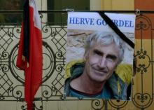 A portrait of mountain guide of Frenchman Herve Gourdel hangs near a French flag outside the town hall in Saint-Martin-Vesubie, September 24, 2014. PHOTO BY REUTERS/Patrice Masante