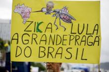 A demonstrator carries a poster during a protest against Brazil's President Dilma Rousseff, part of nationwide protests calling for her impeachment, at Copacabana beach in Rio de Janeiro, Brazil, March 13, 2016. The poster reads, "Zika and Lula are the plague of Brazil", in reference to Brazil's former president Luiz Inacio Lula da Silva. PHOTO BY REUTERS/Ricardo Moraes