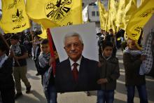 Palestinian boys carry a poster depicting Palestinian President Mahmoud Abbas during a rally marking the 50th anniversary of the founding of the Fatah movement, at Qalandia refugee camp near the West Bank city of Ramallah, January 1, 2015. PHOTO BY REUTERS/Mohamad Torokman
