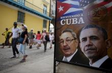 Tourists pass by images of U.S. President Barack Obama and Cuban President Raul Castro in a banner that reads "Welcome to Cuba" at the entrance of a restaurant in downtown Havana, March 17, 2016. PHOTO BY REUTERS/Alexandre Meneghini