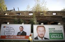 A Bosnian woman walks past election posters in Sarajevo