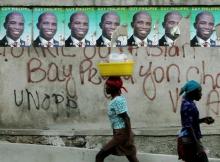 Haitians walk past posters of presidential candidate Guy Philippe at a street in Port-au-Prince, Haiti, February 3, 2006. PHOTO BY REUTERS/Eduardo Munoz