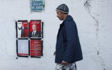 A man walks past election posters of presidential candidates in Tunis, December 16, 2014. PHOTO BY REUTERS/Zoubeir Souissi