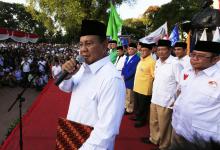 Indonesian presidential candidate Prabowo Subianto (L) talks to his supporters in front of coalition parties chiefs during a signing ceremony of an agreement of his coalition parties in Jakarta