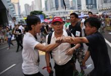 Pro-democracy protesters argue with a man as he walks away from an area blocked by protesters outside the government headquarters office in Hong Kong