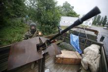 An armed pro-Russian separatist from the so-called Battalion Vostok (East) stands guard at a checkpoint in the eastern Ukrainian city of Donetsk