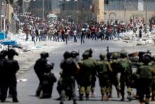 Palestinian protesters hurl stones at Israeli troops following a protest in support of Palestinian prisoners on hunger strike in Israeli jails, in the West Bank village of Beita, near Nablus, May 19, 2017. PHOTO BY REUTERS/Mohamad Torokman