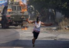 A Palestinian protester runs after throwing a molotov cocktail towards Israeli soldiers during clashes following the funeral of Palestinian youth Laith al-Khaldi, in Jalazoun refugee camp near the West Bank city of Ramallah August 1, 2015. PHOTO BY REUTERS/Mohamad Torokman