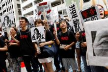 Protesters hold pictures of "comfort women" and of Japan's Prime Minister Shinzo Abe with Chinese characters reading "apologise", outside Japan’s de facto embassy in Taipei, Taiwan, August 14, 2018. PHOTO BY REUTERS/Tyrone Siu