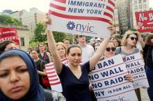 Protesters hold signs against U.S. President Donald Trump's limited travel ban, approved by the U.S. Supreme Court, in New York City, U.S., June 29, 2017. PHOTO BY REUTERS/Joe Penney