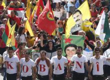 Kurdish protesters wear shirts forming the word 'Kobani' as others wave Lebanese and Kurdish flags and carry the image of Abdullah Ocalan, jailed leader of the Kurdistan Workers' Party (PKK), during a demonstration against Islamic State (IS) insurgent attacks on the Syrian Kurdish town of Kobani, in Beirut