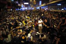 Pro-democracy protesters sit on a street as they block an area of the Mongkok shopping district of Hong Kong, October 20, 2014. PHOTO BY REUTERS/Carlos Barria