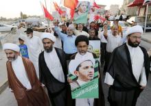 Protesters hold photos of Sheikh Ali Salman, Bahrain's main opposition leader and Secretary-General of Al-Wefaq Islamic Society, as they march asking for his release in the village of Jidhafs, west of Manama, Bahrain, June 16, 2015. PHOTO BY REUTERS/Hamad I Mohammed