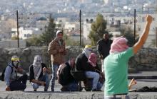 Palestinian protesters take cover during clashes with Israeli troops in the West Bank city of Bethlehem, January 13, 2016. PHOTO BY REUTERS/Ammar Awad