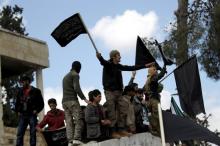 Protesters carry Nusra Front flags and shout slogans during an anti-government protest after Friday prayers in the town of Marat Numan in Idlib province, Syria, March 11, 2016. PHOTO BY REUTERS/Khalil Ashawi
