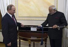 Russia's President Vladimir Putin (L) and India's Prime Minister Narendra Modi exchange presents during a meeting at the Kremlin in Moscow, Russia, December 23, 2015. PHOTO BY REUTERS/Alexey Nikolsky